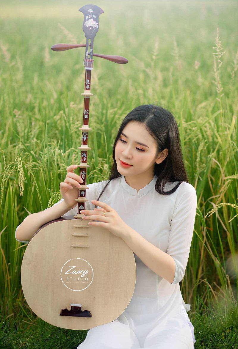 Tao Wi, cô mặc áo dài và thả dáng trên cánh đồng. 